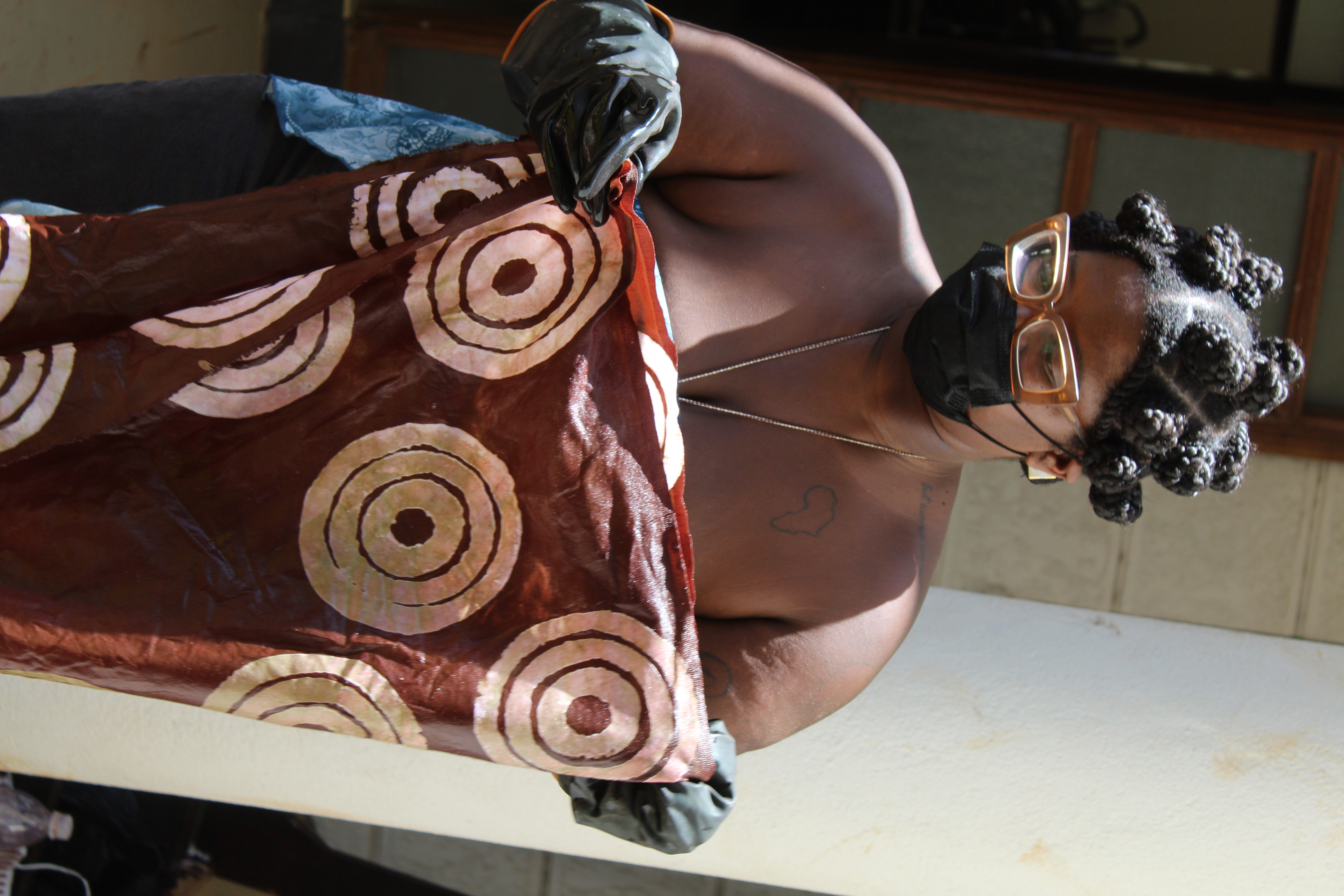 A finished batik cloth being inspected by hand