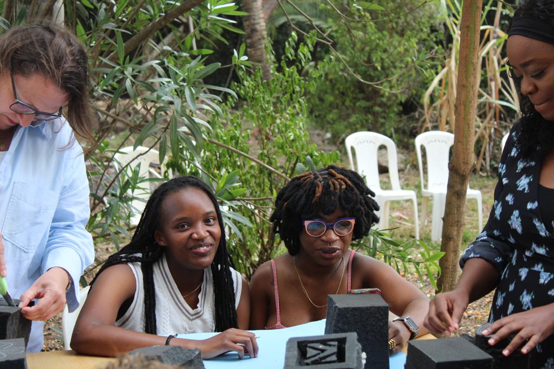 Workshop participants learning around a studio table